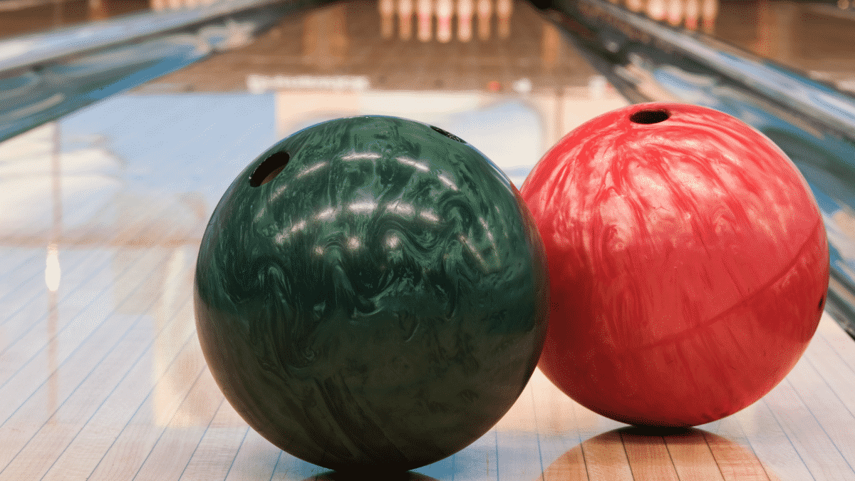 Green and red bowling ball in an alley